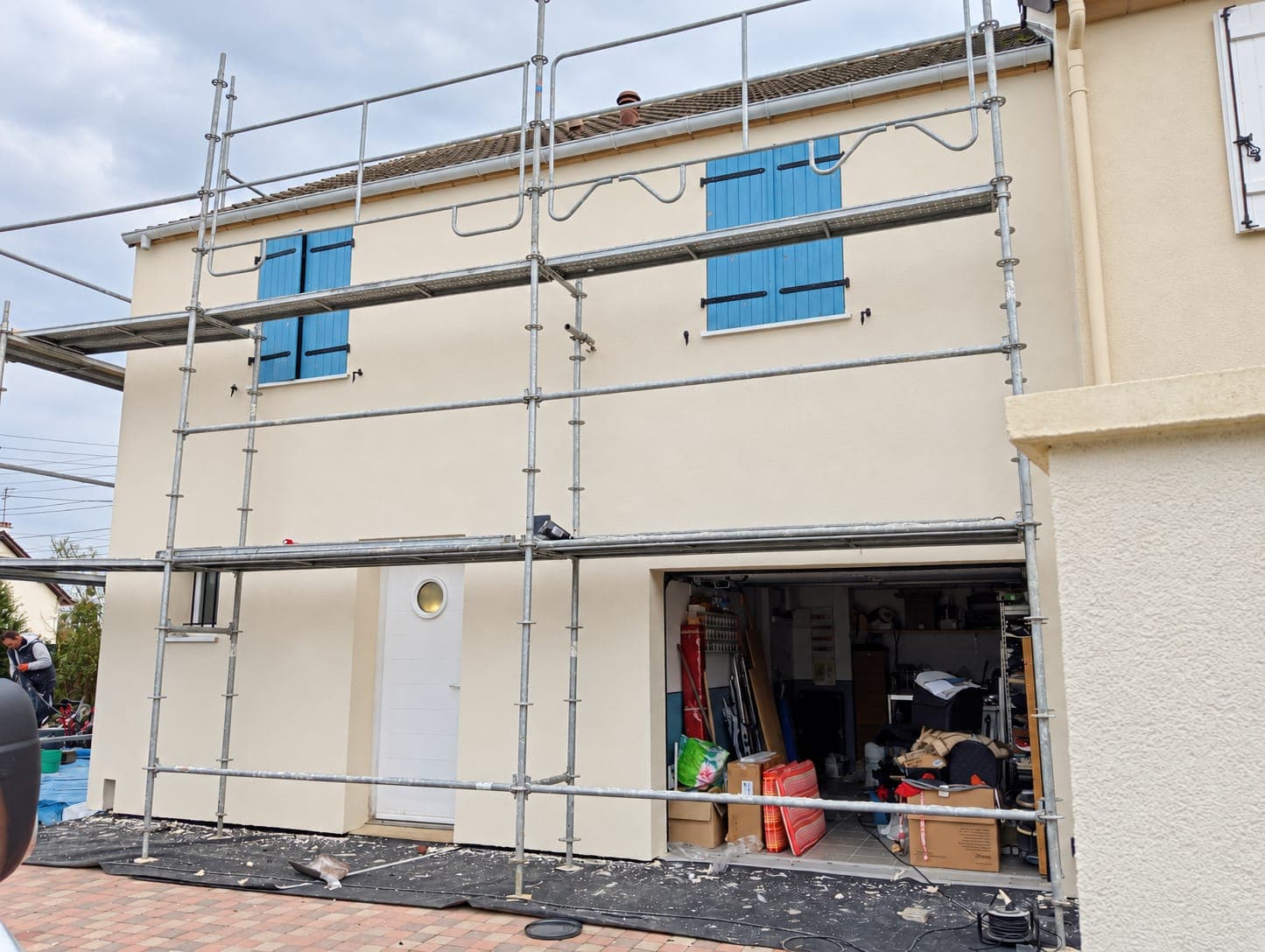 La façade d’une maison sous échafaudage pendant des travaux d’isolation.